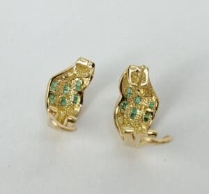 Gold cat-shaped earrings with turquoise accents.