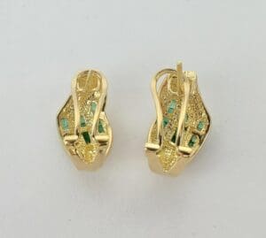 Gold earrings with green gemstone accents.