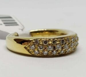 Gold ring with diamond accents and tag.