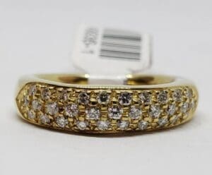 Gold ring with diamond accents and tag.