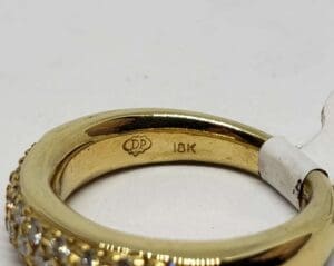 Gold ring with "18K" and diamond details.