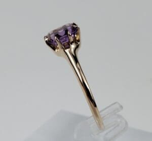 Gold ring with a purple gemstone.