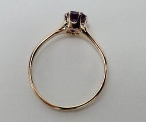 Gold ring with purple gemstone setting.