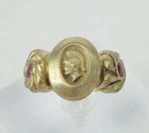 Gold ring with engraved profile and gems.