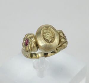 Gold ring with engraved profile and stones.