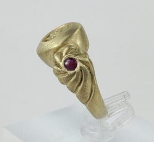 Gold ring with red gemstone design.