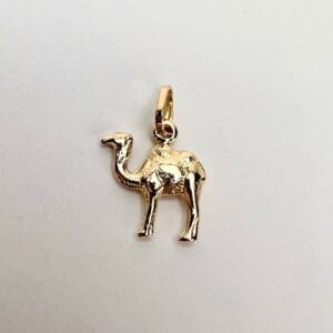 Gold camel-shaped pendant on white background.