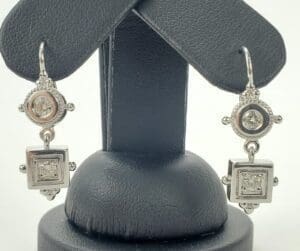 Silver earrings with square and round designs.