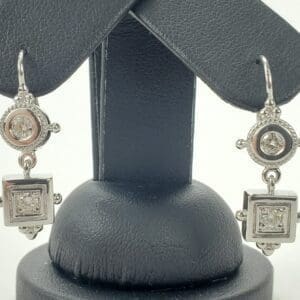 Silver earrings with square and round designs.