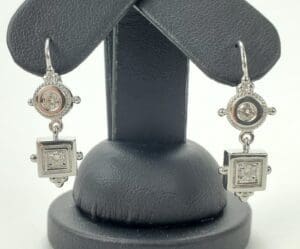 Silver ornate earrings with geometric designs.