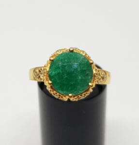 Gold ring with a large green gemstone.