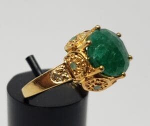 Gold ring with large green gemstone.