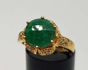 Gold ring with large green gemstone.