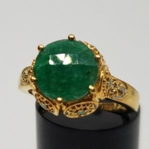 Gold ring with large green gemstone.