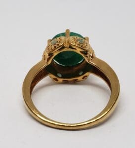 Gold ring with green gemstone setting.