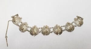 Ornate silver bracelet with floral design.