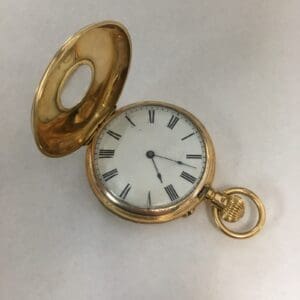 Open gold pocket watch on white background.