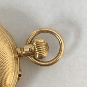 Gold pocket watch with textured casing.