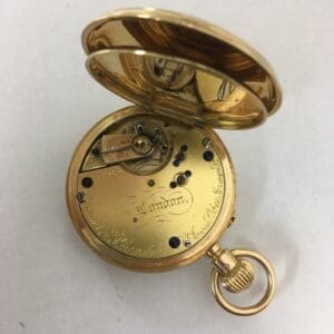 Gold pocket watch with open cover.