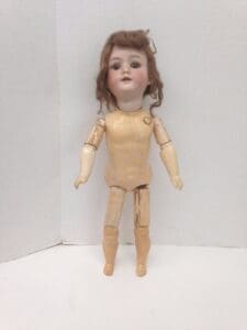 Antique doll with jointed wooden body.