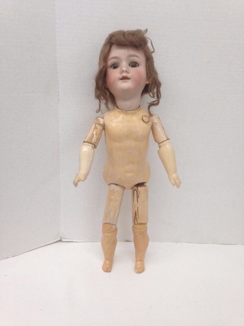 Antique doll with jointed wooden body.