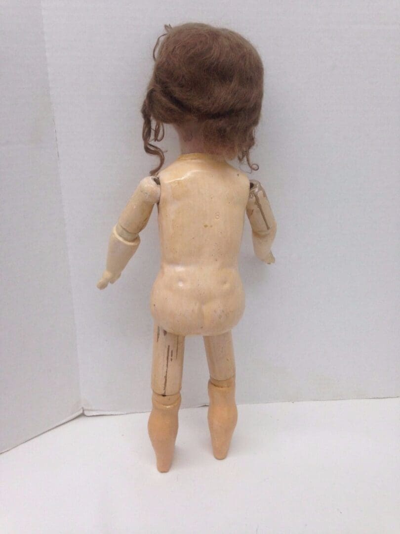Back view of a vintage wooden doll.