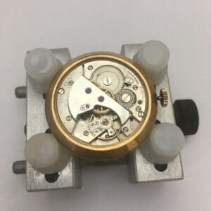 Watch movement mechanism on a metal holder.