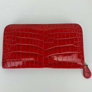 Red crocodile-patterned leather wallet on display.