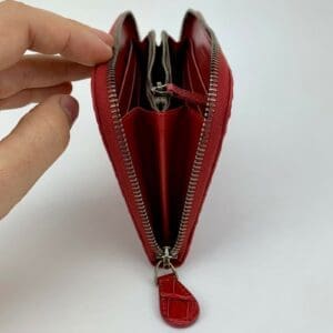 Red wallet with multiple compartments, unzipped.