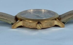 Gold wristwatch with a leather strap.