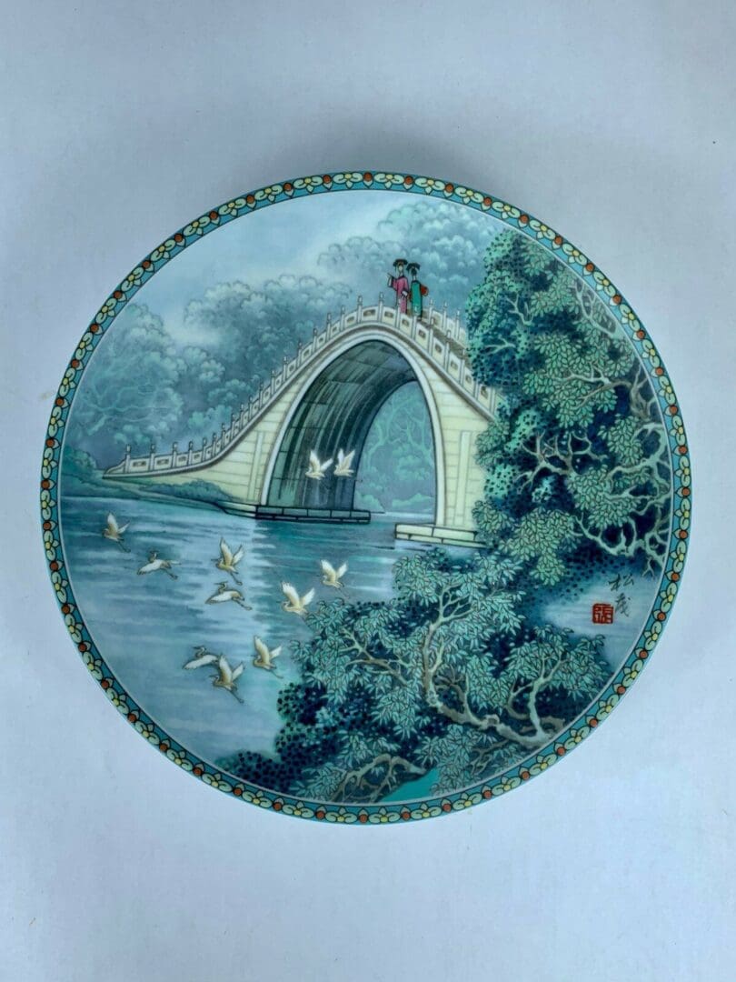 Decorative plate with bridge and birds design.