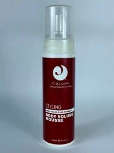 Red bottle of hair styling mousse.