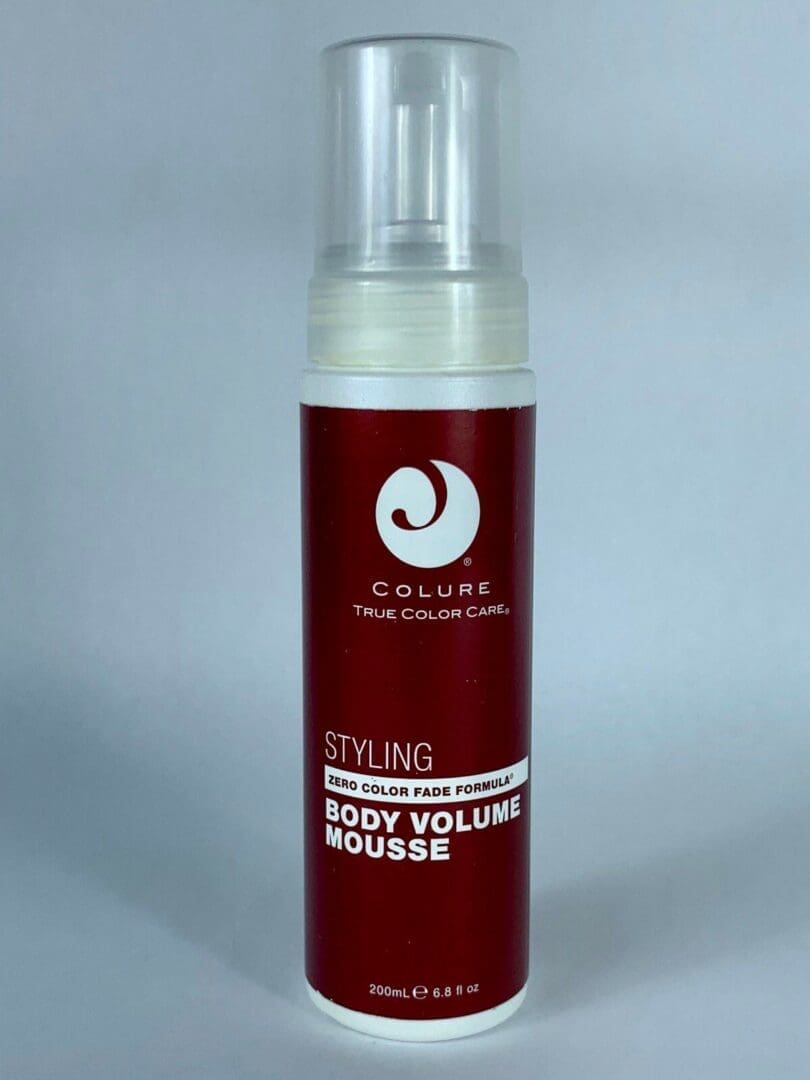 Red bottle of hair styling mousse.