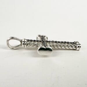 Silver cross pendant with twisted design.