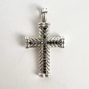 Silver cross pendant with black stones.