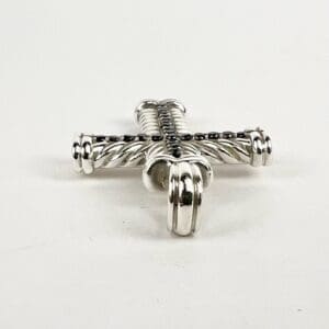Silver cross pendant on white background.