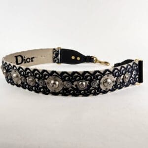 Embroidered Dior strap with decorative metal accents.