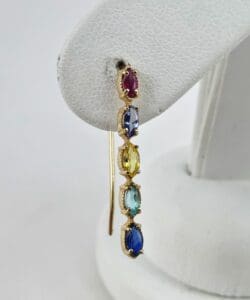 Multi-colored gemstone earring on white display.