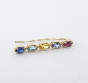 Gold earring with colorful gemstones.