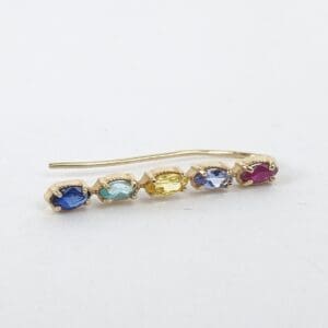 Gold earring with colorful gemstones.