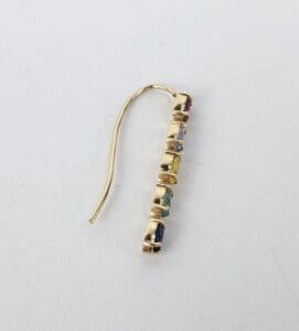 Gold earring with colorful gemstones.