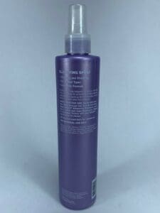Purple clarifying spray bottle on plain background.