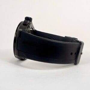 Black wristwatch with rubber strap, side view.