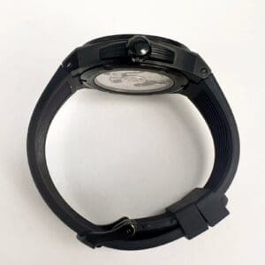 Black wristwatch with round face, side view.