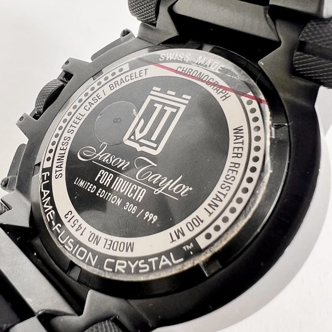 Watch back with engraved details and logo.