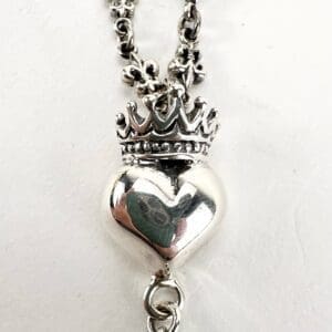 Silver heart pendant with crown design.