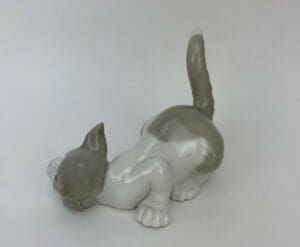 Ceramic figurine of playful cat stretching.