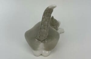 Ceramic cat figurine with raised tail.