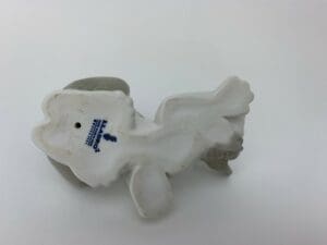 Porcelain figurine base with manufacturer stamp.