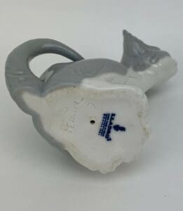 Porcelain figurine base with maker's mark.